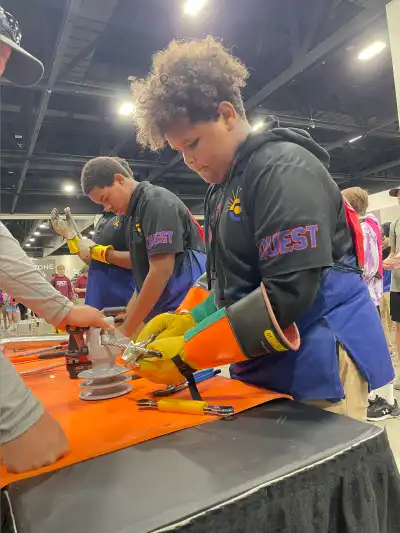 a student uses tools to practice the job of a lineman